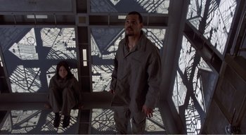 Movie still from “Cube” (1997), directed by Vincenzo Natali – A man and a woman are standing in a building; Wide shot, High angle