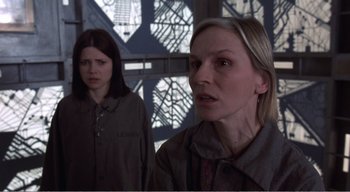 Movie still from “Cube” (1997), directed by Vincenzo Natali – Two women are standing next to each other; Close Up shot, Low angle