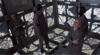 Movie still from “Cube” (1997), directed by Vincenzo Natali – Two men standing next to each other in a room; Wide shot, High angle