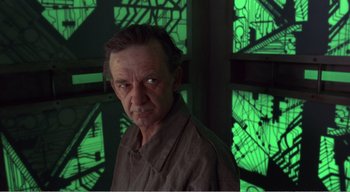 Movie still from “Cube” (1997), directed by Vincenzo Natali – A person in a green room; Close Up shot, Low angle
