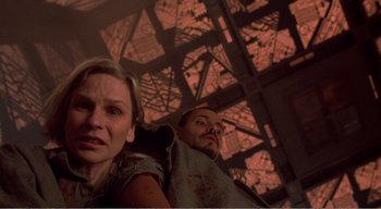 Movie still from “Cube” (1997), directed by Vincenzo Natali – A man and a woman standing next to each other; Close Up shot, Overhead angle