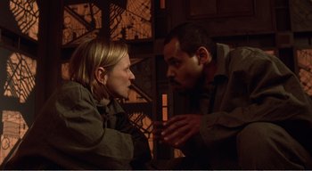 Movie still from “Cube” (1997), directed by Vincenzo Natali – A man and a woman talking to each other; Medium shot, High angle