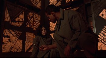 Movie still from “Cube” (1997), directed by Vincenzo Natali – A man and a woman are holding a pair of shears; Medium shot, High angle