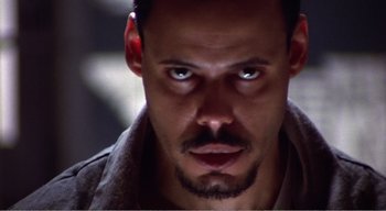 Movie still from “Cube” (1997), directed by Vincenzo Natali – A person with a beard; Close Up shot, Low angle