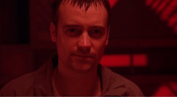 Movie still from “Cube” (1997), directed by Vincenzo Natali – A person in a dark room; Close Up shot, Low angle