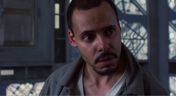 Movie still from “Cube” (1997), directed by Vincenzo Natali – A person wearing a jacket; Close Up shot, High angle