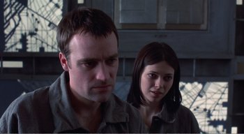 Movie still from “Cube” (1997), directed by Vincenzo Natali – A man and a woman standing next to each other; Close Up shot, Low angle