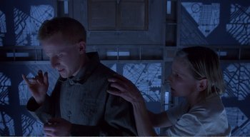 Movie still from “Cube” (1997), directed by Vincenzo Natali – A man and a woman are in a room; Medium shot, Low angle