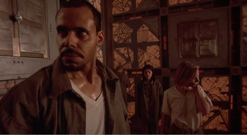 Movie still from “Cube” (1997), directed by Vincenzo Natali – A group of people standing next to each other in a room; Medium shot, Low angle