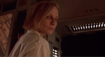 Movie still from “Cube” (1997), directed by Vincenzo Natali – A woman in a white shirt is looking at the camera; Close Up shot, Low angle