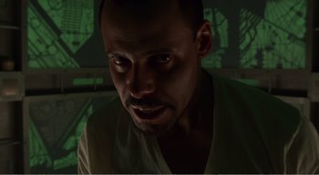 Movie still from “Cube” (1997), directed by Vincenzo Natali – A person looking at the camera; Close Up shot, Low angle