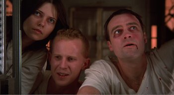 Movie still from “Cube” (1997), directed by Vincenzo Natali – A group of people that are looking at the camera; Close Up shot, Low angle
