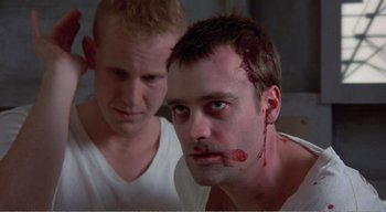 Movie still from “Cube” (1997), directed by Vincenzo Natali – A man with blood on his face and another man with blood on his face; Close Up shot, Low angle
