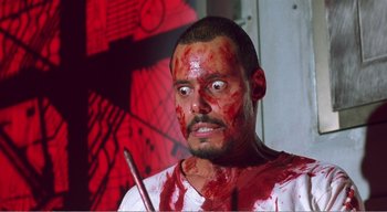 Movie still from “Cube” (1997), directed by Vincenzo Natali – A man with blood all over his face and body; Close Up shot, Low angle