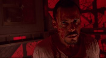 Movie still from “Cube” (1997), directed by Vincenzo Natali – A person with blood all over his face; Close Up shot, Low angle