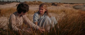 Movie still from “The Greatest Showman” (2017), directed by Michael Gracey – Two people sitting in the grass in a field; Medium shot, Over the shoulder angle