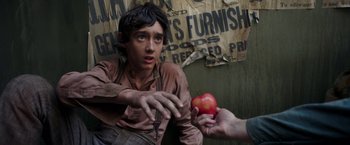Movie still from “The Greatest Showman” (2017), directed by Michael Gracey – A young man holding an apple in his hand; Close Up shot, Overhead angle