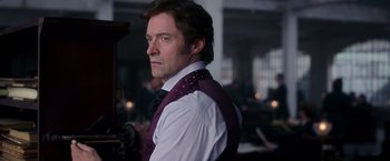 Movie still from “The Greatest Showman” (2017), directed by Michael Gracey – A man in a white shirt and a purple tie; Close Up shot, Over the shoulder angle