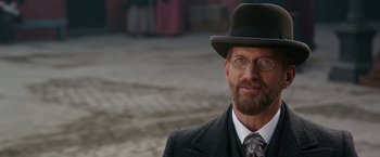 Movie still from “The Greatest Showman” (2017), directed by Michael Gracey – A man with a beard wearing a suit and a hat; Close Up shot, Over the shoulder angle