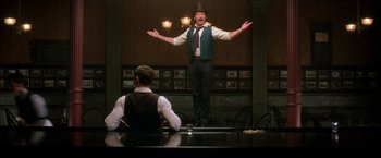 Movie still from “The Greatest Showman” (2017), directed by Michael Gracey – A man standing up with his arms outstretched; Wide shot, Low angle