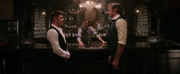 Movie still from “The Greatest Showman” (2017), directed by Michael Gracey – Three men are standing at a bar talking to each other; Medium shot, Over the shoulder angle
