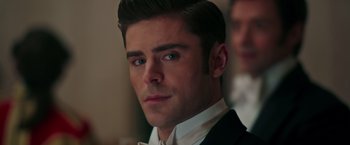 Movie still from “The Greatest Showman” (2017), directed by Michael Gracey – A man in a suit and white shirt looking at the camera; Close Up shot, Over the shoulder angle