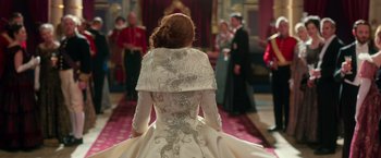 Movie still from “The Greatest Showman” (2017), directed by Michael Gracey – A woman in a white dress standing in front of a group of people; Medium shot, Over the shoulder angle
