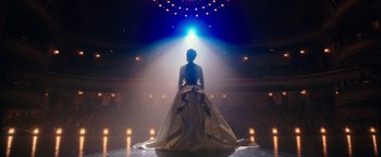 Movie still from “The Greatest Showman” (2017), directed by Michael Gracey – A woman standing on a stage wearing a dress; Wide shot, Low angle
