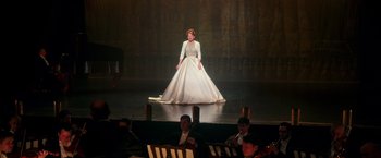 Movie still from “The Greatest Showman” (2017), directed by Michael Gracey – A woman in a white dress standing on a stage; Wide shot, Low angle