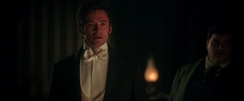 Movie still from “The Greatest Showman” (2017), directed by Michael Gracey – A person wearing a suit and bow tie; Close Up shot, Over the shoulder angle