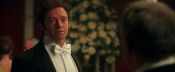 Movie still from “The Greatest Showman” (2017), directed by Michael Gracey – A person wearing a suit and bow tie; Close Up shot, Over the shoulder angle