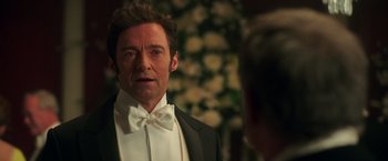 Movie still from “The Greatest Showman” (2017), directed by Michael Gracey – A person wearing a suit and bow tie; Close Up shot, Over the shoulder angle