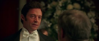 Movie still from “The Greatest Showman” (2017), directed by Michael Gracey – A person wearing a suit and tie; Close Up shot, Over the shoulder angle