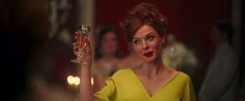 Movie still from “The Greatest Showman” (2017), directed by Michael Gracey – A woman in a yellow dress holding a glass of wine; Close Up shot, Low angle