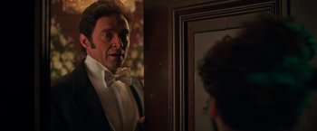 Movie still from “The Greatest Showman” (2017), directed by Michael Gracey – A person wearing a suit and bow tie; Close Up shot, Over the shoulder angle