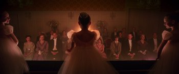 Movie still from “The Greatest Showman” (2017), directed by Michael Gracey – A little girl in a dress standing in front of a crowd; Wide shot, Over the shoulder angle