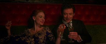 Movie still from “The Greatest Showman” (2017), directed by Michael Gracey – A man and a woman sitting next to each other holding champagne flutes; Medium shot, Low angle