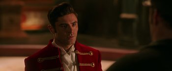 Movie still from “The Greatest Showman” (2017), directed by Michael Gracey – A man in a red jacket looking to his left; Close Up shot, Over the shoulder angle