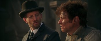 Movie still from “The Greatest Showman” (2017), directed by Michael Gracey – A man in a suit and a hat talking to another man in a suit; Close Up shot, Over the shoulder angle