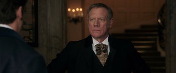 Movie still from “The Greatest Showman” (2017), directed by Michael Gracey – An older man wearing a suit and tie; Close Up shot, Low angle