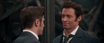 Movie still from “The Greatest Showman” (2017), directed by Michael Gracey – Two men in business suits talking to each other; Close Up shot, Over the shoulder angle