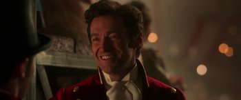 Movie still from “The Greatest Showman” (2017), directed by Michael Gracey – A person wearing a suit and tie; Close Up shot, Over the shoulder angle