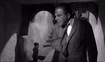 Movie still from “Cul-de-sac” (1966), directed by Roman Polanski – An old photo of a man and a young boy; Medium shot, Low angle