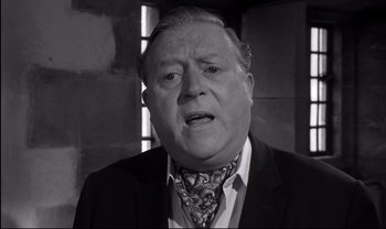 Movie still from “Cul-de-sac” (1966), directed by Roman Polanski – An older man wearing a suit and a neck tie; Close Up shot, Low angle
