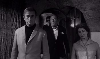 Movie still from “Cul-de-sac” (1966), directed by Roman Polanski – A black and white photo of a group of people in a tunnel; Medium shot, Low angle