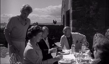 Movie still from “Cul-de-sac” (1966), directed by Roman Polanski – A black and white photo of people sitting at a table; Medium shot, Low angle