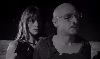 Movie still from “Cul-de-sac” (1966), directed by Roman Polanski – A man and a woman standing next to each other; Close Up shot, Low angle