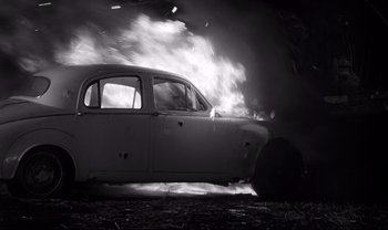 Movie still from “Cul-de-sac” (1966), directed by Roman Polanski – An old car is in the middle of the night; Wide shot, High angle