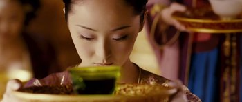 Movie still from “Curse of the Golden Flower” (2006), directed by Yimou Zhang – A person holding a container of food; Close Up shot, Low angle