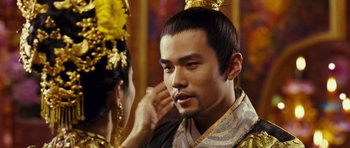 Movie still from “Curse of the Golden Flower” (2006), directed by Yimou Zhang – A man and a woman in traditional chinese clothing; Close Up shot, Over the shoulder angle